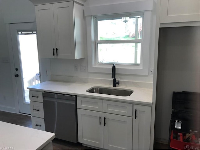 kitchen with dishwasher, white cabinetry, and sink