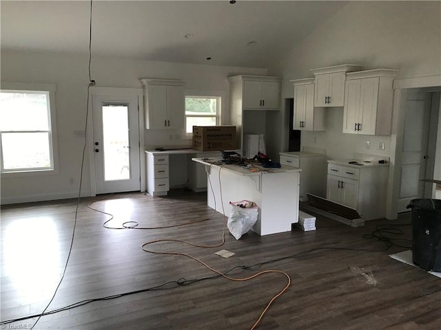 kitchen featuring high vaulted ceiling, a center island, hardwood / wood-style flooring, and white cabinetry