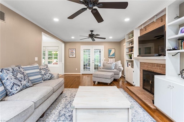 3717 Rock Haven Dr, Greensboro, NC 27410 - living room featuring crown molding, wood finished floors, a ceiling fan, french doors, and a fireplace