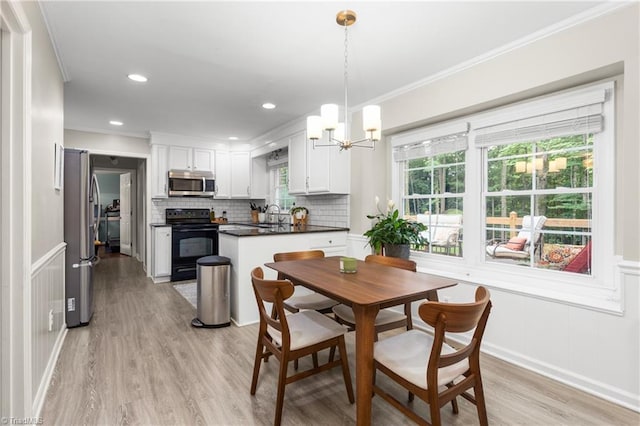 3717 Rock Haven Dr, Greensboro, NC 27410 - dining space with light wood-style floors, ornamental molding, a chandelier, recessed lighting, and a decorative wall