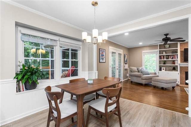 3717 Rock Haven Dr, Greensboro, NC 27410 - dining space with light wood-style flooring, ornamental molding, a chandelier, french doors, and a decorative wall