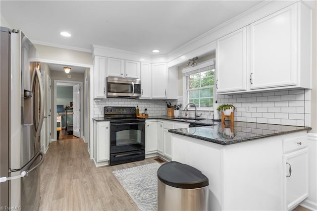 3717 Rock Haven Dr, Greensboro, NC 27410 - kitchen with appliances with stainless steel finishes, white cabinets, light wood finished floors, a peninsula, and ornamental molding