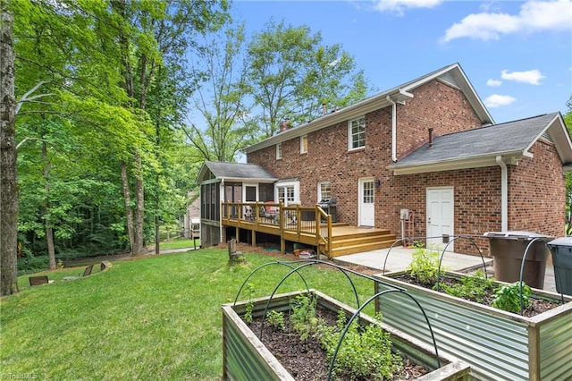 3717 Rock Haven Dr, Greensboro, NC 27410 - back of house featuring brick siding, a lawn, a wooden deck, a vegetable garden, and a sunroom
