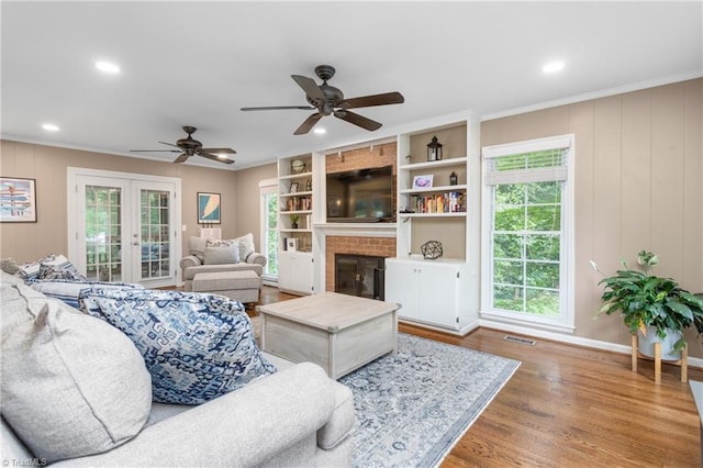 3717 Rock Haven Dr, Greensboro, NC 27410 - living room with french doors, crown molding, a fireplace, wood finished floors, and ceiling fan