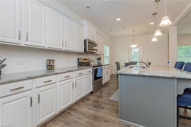 5968 Crescentbrook Ln, Clemmons, NC 27012 - kitchen featuring stainless steel appliances, white cabinetry, a sink, recessed lighting, and wood finished floors