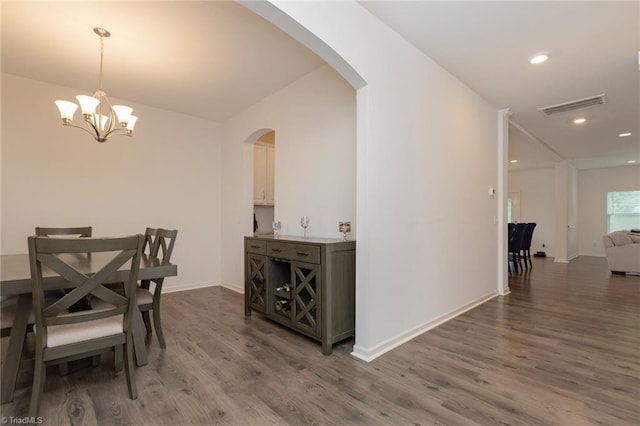 5968 Crescentbrook Ln, Clemmons, NC 27012 - dining space featuring arched walkways, wood finished floors, a chandelier, recessed lighting, and baseboards