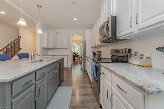 5968 Crescentbrook Ln, Clemmons, NC 27012 - kitchen with stainless steel appliances, a sink, gray cabinets, arched walkways, and white cabinets
