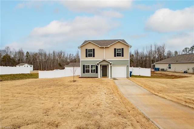 traditional-style home featuring a garage, a front yard, fence, and driveway