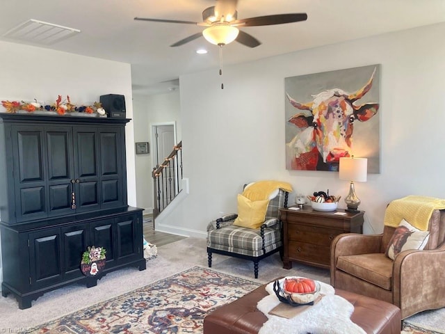 carpeted living room with ceiling fan