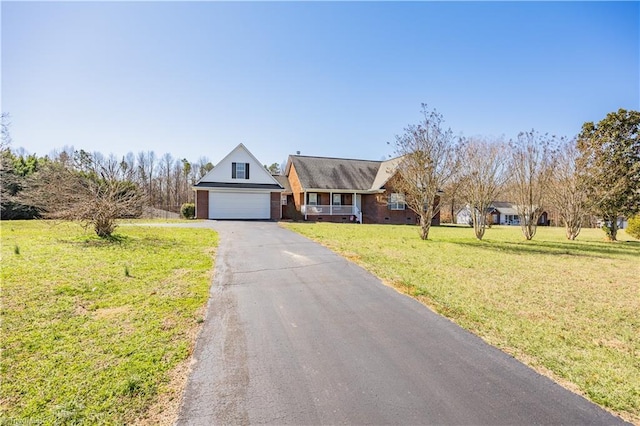 view of front of home featuring a front lawn, an attached garage, brick siding, and aphalt driveway