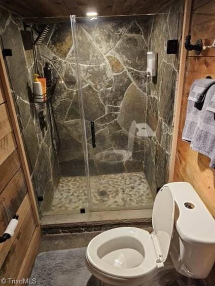 bathroom with toilet and an enclosed shower