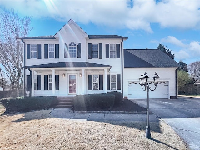 colonial home featuring an attached garage, covered porch, and driveway