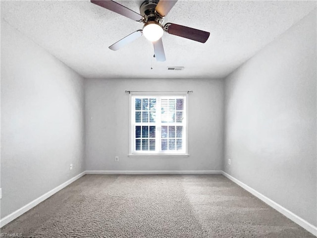 empty room featuring ceiling fan, a textured ceiling, baseboards, and carpet floors