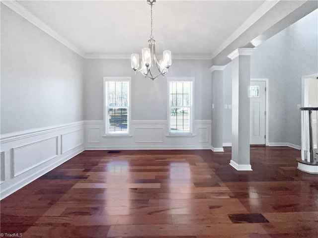 unfurnished dining area featuring wainscoting, ornamental molding, an inviting chandelier, and wood finished floors