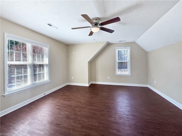 bonus room featuring a ceiling fan, wood finished floors, visible vents, baseboards, and a textured ceiling