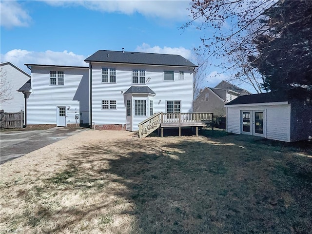 back of property with an outbuilding, french doors, a wooden deck, and a yard