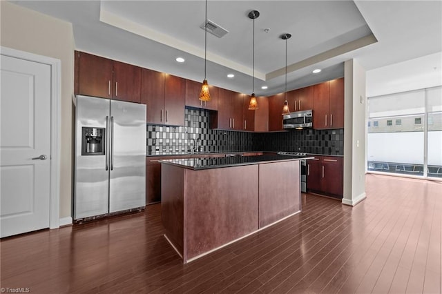 201 N Elm St Unit 703, Greensboro, NC 27401 - kitchen featuring stainless steel appliances, a tray ceiling, decorative backsplash, dark countertops, and recessed lighting