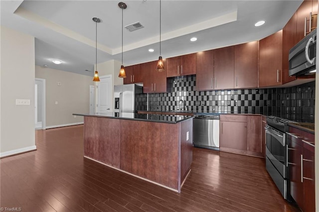 201 N Elm St Unit 703, Greensboro, NC 27401 - kitchen featuring appliances with stainless steel finishes, a raised ceiling, dark countertops, and recessed lighting