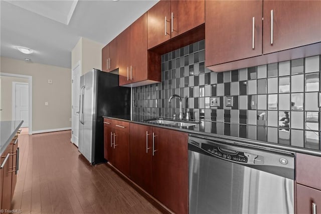 201 N Elm St Unit 703, Greensboro, NC 27401 - kitchen with stainless steel appliances, a sink, backsplash, dark wood-style floors, and baseboards