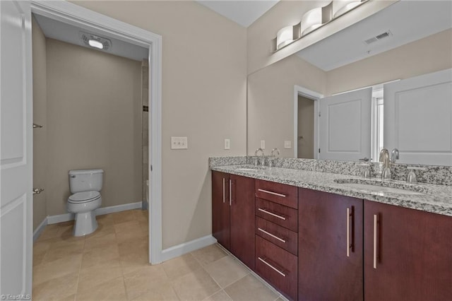 201 N Elm St Unit 703, Greensboro, NC 27401 - bathroom with baseboards, toilet, double vanity, and tile patterned flooring