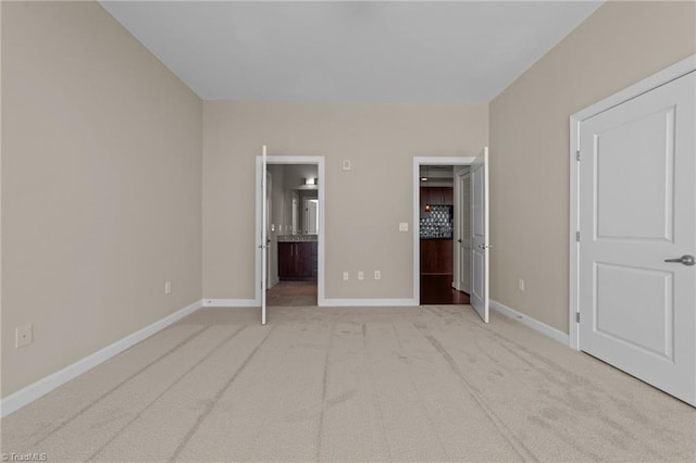 201 N Elm St Unit 703, Greensboro, NC 27401 - unfurnished bedroom featuring baseboards, carpet floors, and ensuite bathroom