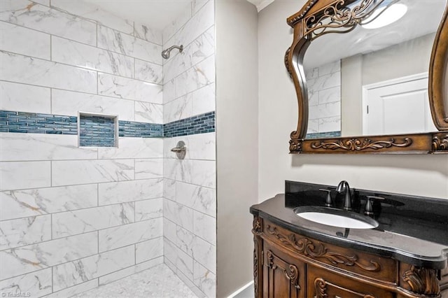 bathroom with tiled shower and vanity
