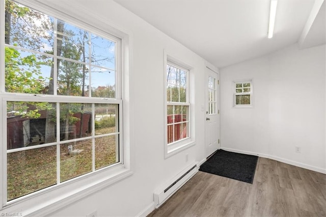 doorway with baseboard heating, lofted ceiling, and hardwood / wood-style flooring