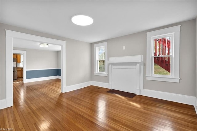 unfurnished living room featuring hardwood / wood-style floors and a healthy amount of sunlight