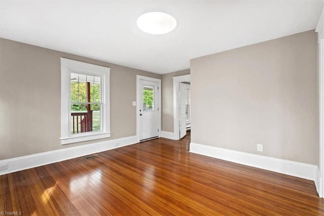 unfurnished room with dark wood-type flooring