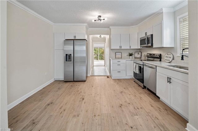 kitchen featuring white cabinets, light hardwood / wood-style floors, appliances with stainless steel finishes, and sink