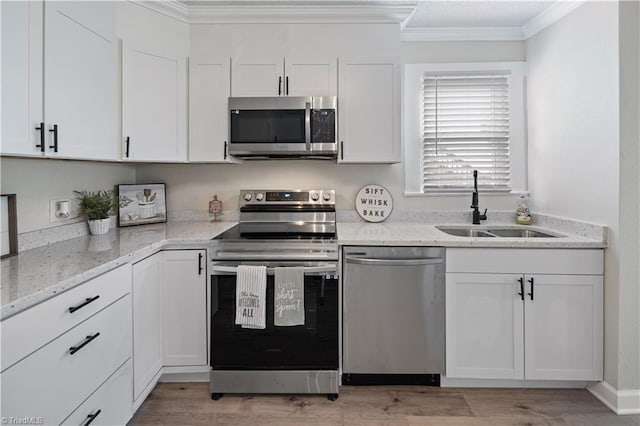 kitchen featuring white cabinetry, stainless steel appliances, ornamental molding, and sink