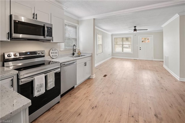 kitchen featuring white cabinetry, stainless steel appliances, crown molding, and light hardwood / wood-style flooring