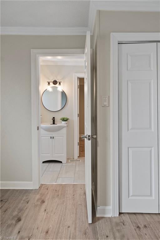 bathroom with vanity, hardwood / wood-style flooring, and crown molding