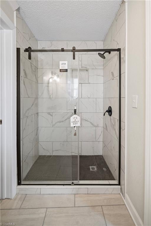 bathroom with walk in shower, tile patterned flooring, and a textured ceiling