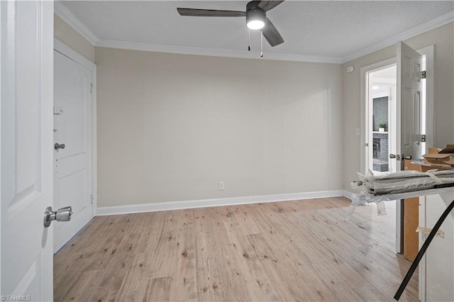 spare room with ceiling fan, a textured ceiling, light wood-type flooring, and crown molding