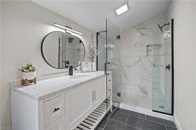 bathroom with walk in shower, tile patterned flooring, vanity, and a textured ceiling