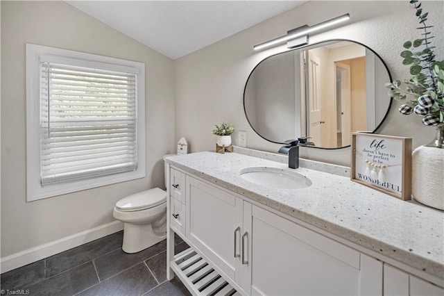 bathroom with vanity, tile patterned flooring, toilet, and vaulted ceiling