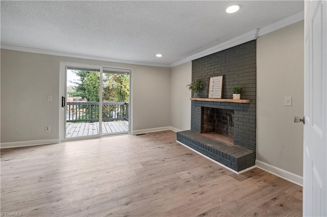 unfurnished living room with a brick fireplace, a textured ceiling, light wood-type flooring, and crown molding