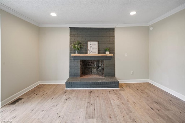 unfurnished living room featuring a textured ceiling, hardwood / wood-style floors, crown molding, and a fireplace