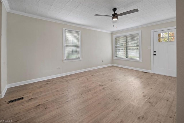 spare room featuring ornamental molding, light wood-type flooring, a healthy amount of sunlight, and ceiling fan