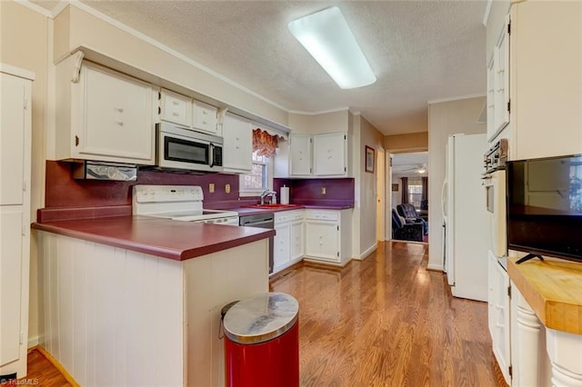 kitchen featuring white cabinetry, kitchen peninsula, stainless steel appliances, light hardwood / wood-style flooring, and a textured ceiling