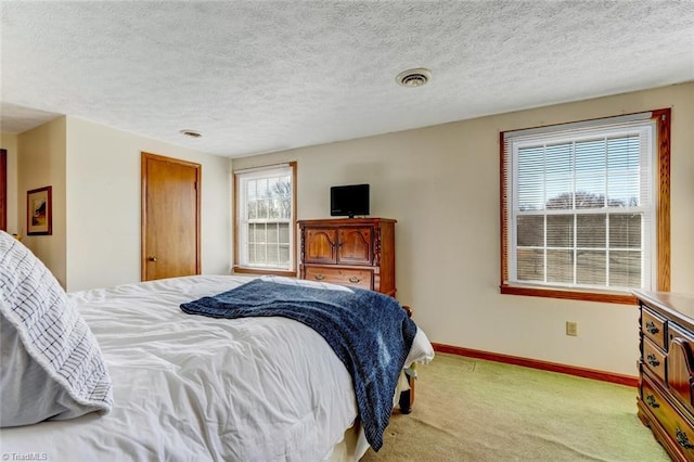 bedroom with light carpet and a textured ceiling