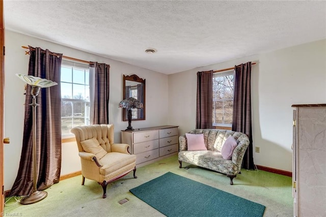 living area featuring light carpet and a textured ceiling