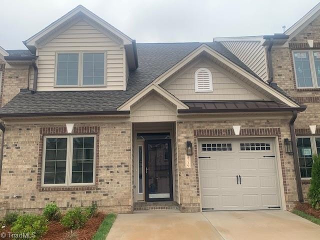 view of front of home with brick siding, concrete driveway, a garage, and a shingled roof