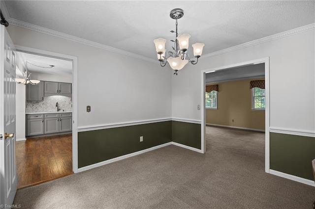 2424 Limner Ln, Winston-Salem, NC 27106 - spare room with a chandelier, a sink, crown molding, dark colored carpet, and baseboards