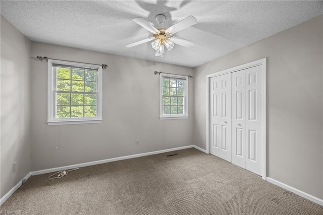 2424 Limner Ln, Winston-Salem, NC 27106 - unfurnished bedroom featuring multiple windows, carpet floors, a closet, a textured ceiling, and baseboards