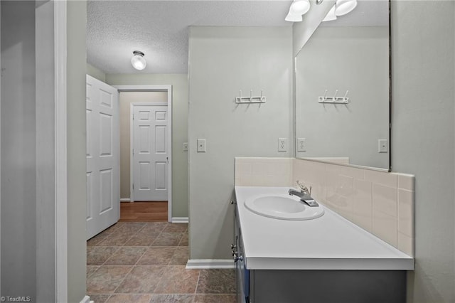 2424 Limner Ln, Winston-Salem, NC 27106 - bathroom with vanity, baseboards, a textured ceiling, and tasteful backsplash