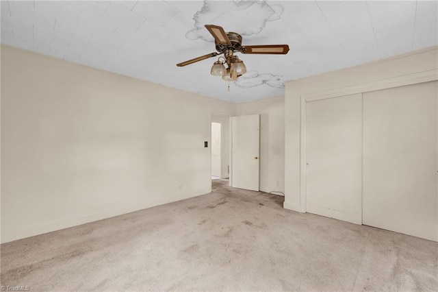 empty room featuring ceiling fan and light colored carpet