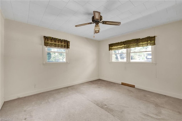 carpeted spare room with ceiling fan and a wealth of natural light