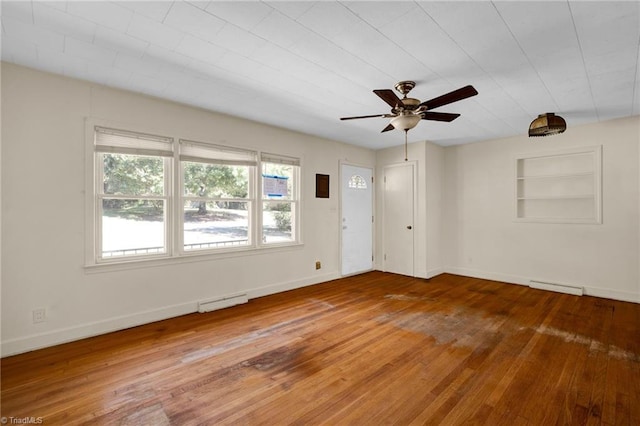 unfurnished room with ceiling fan, built in features, and hardwood / wood-style floors